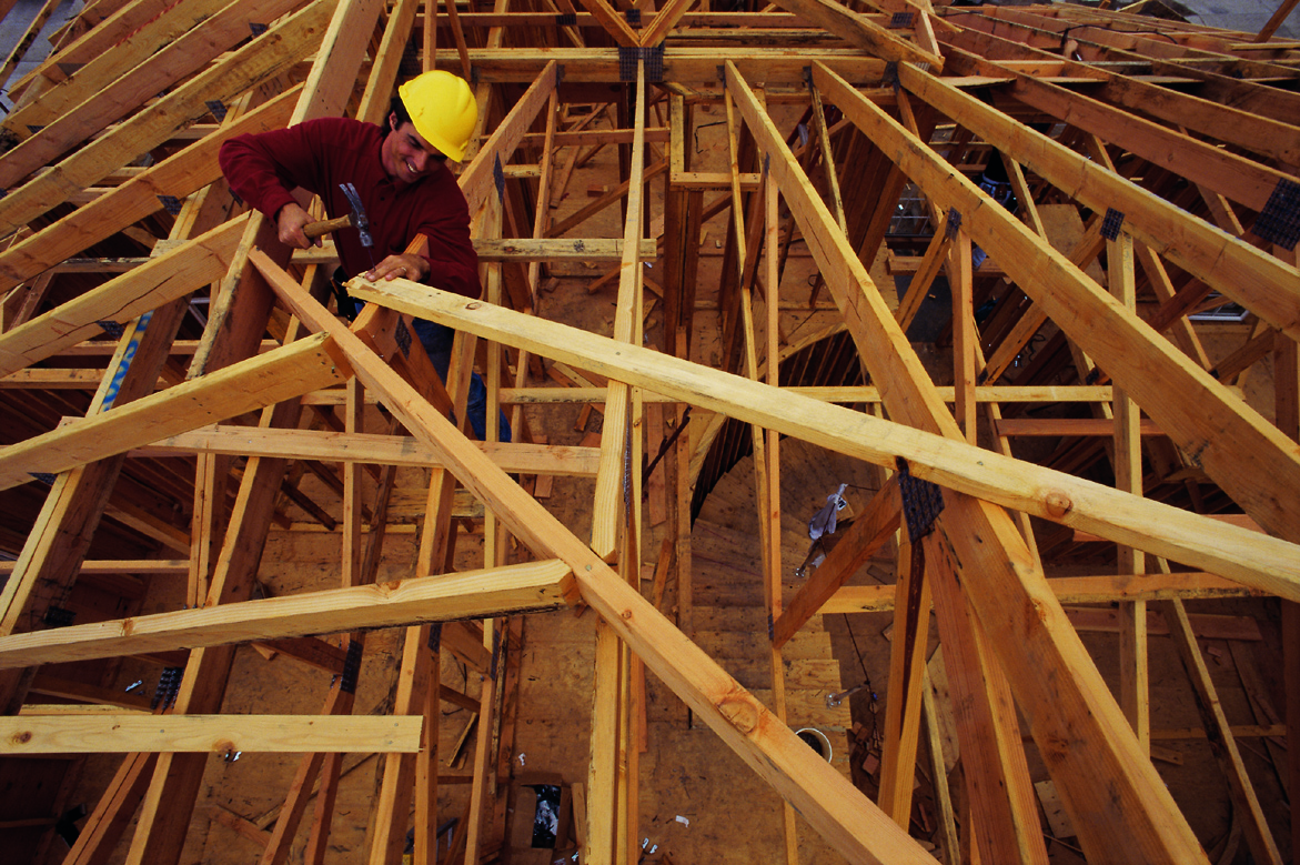 Man constructing timber roof frame.