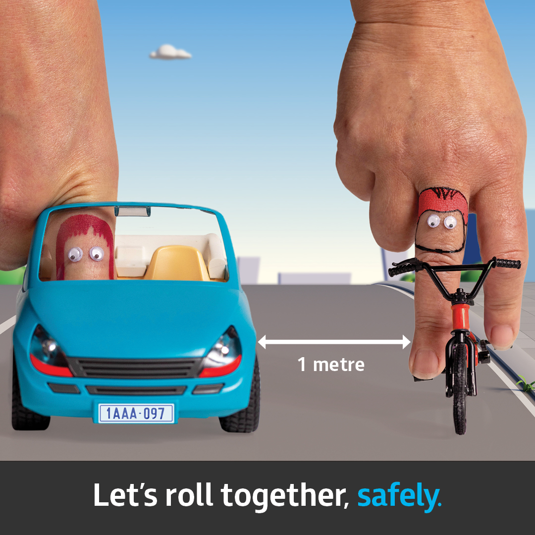 A blue car shares a road with a cyclist, making sure there is 1 metre distance between them.
