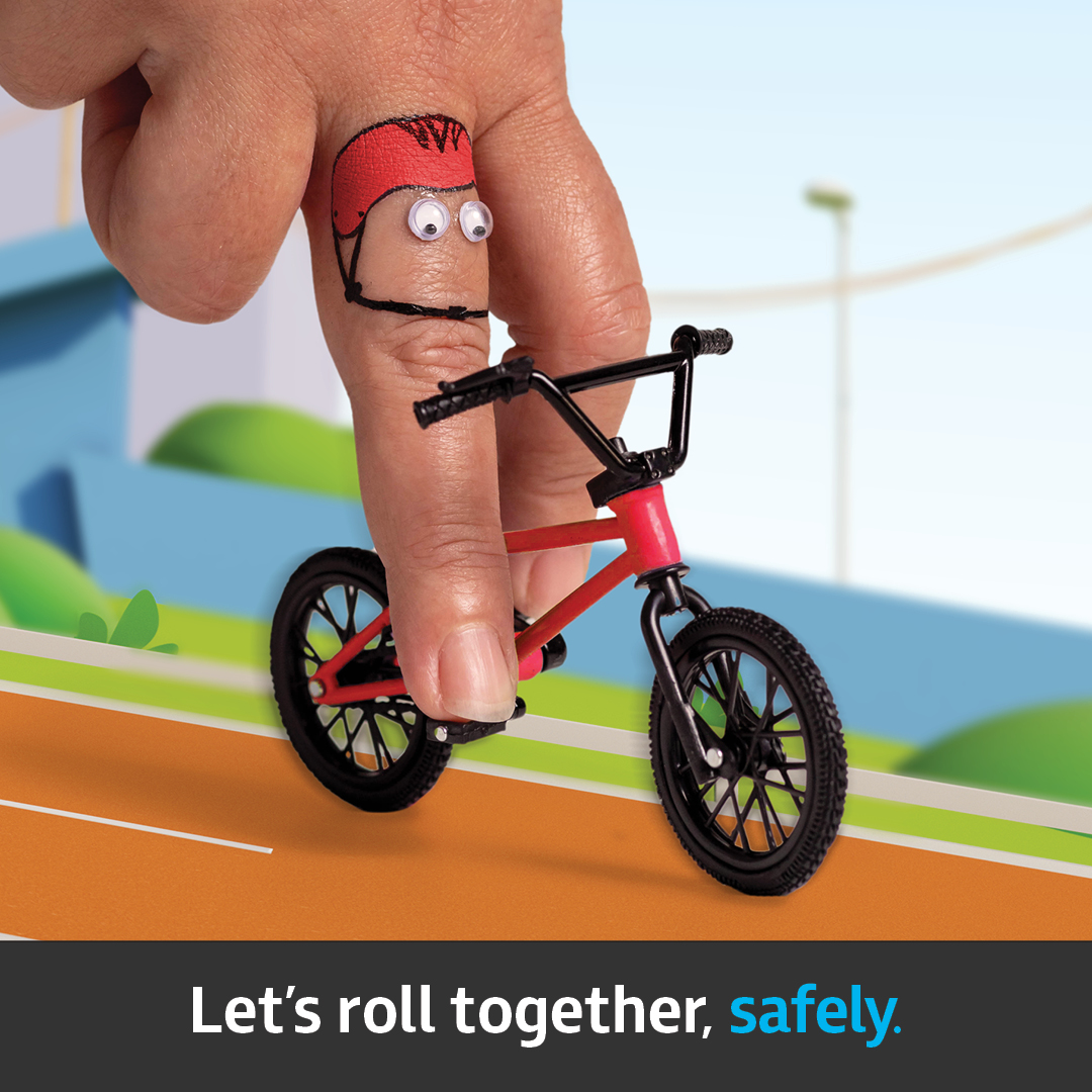 A finger pretending to ride a bike down a stylised street