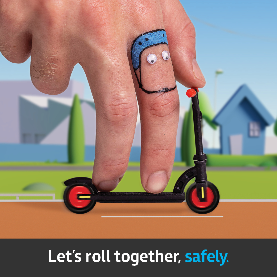 A finger pretending to ride an escooter down a stylised street