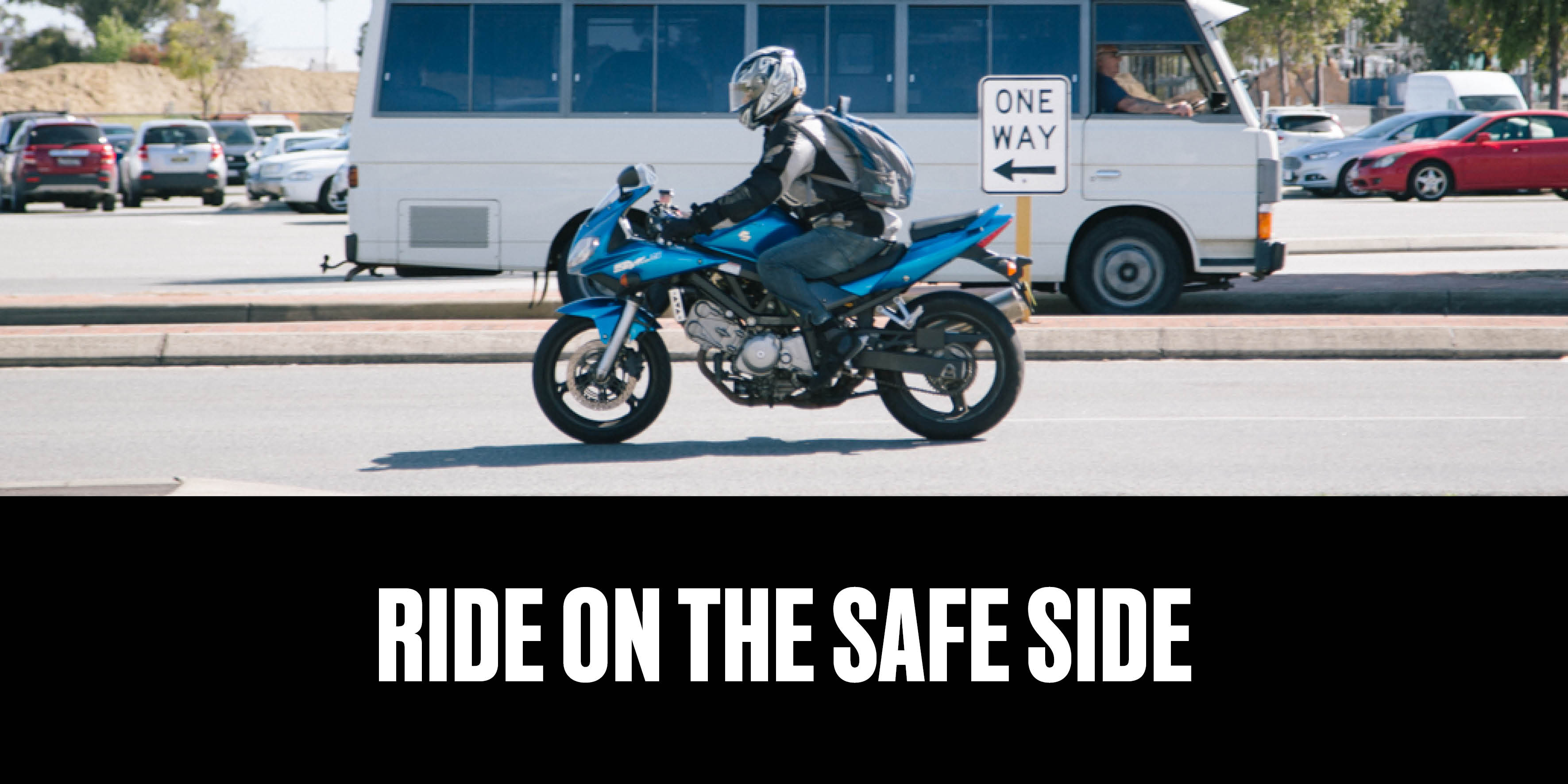 Person riding a motorcycle on the road with text "ride on the safe side"