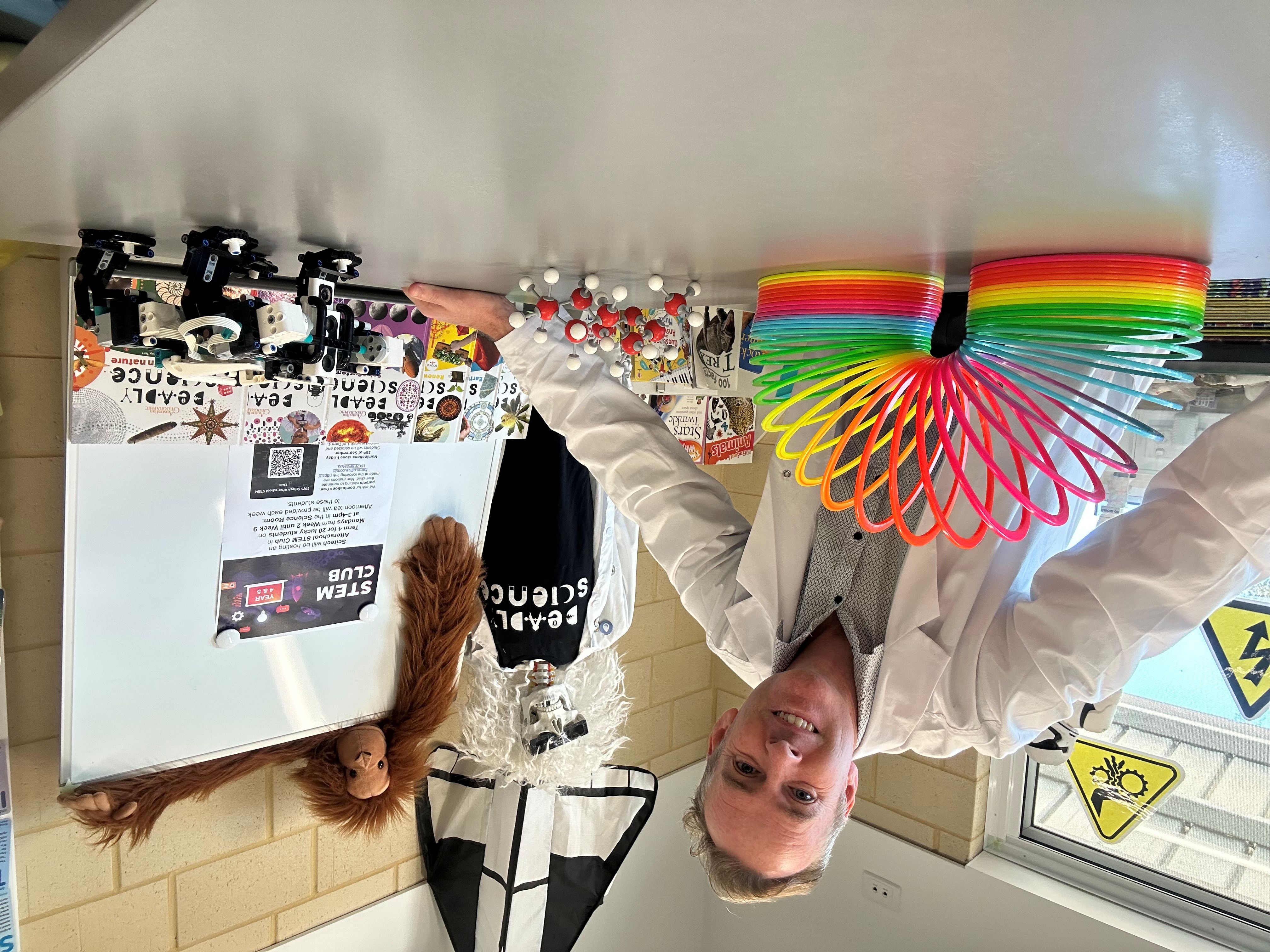 psa finalist chris lambe standing over school desk with science experiment equipment 