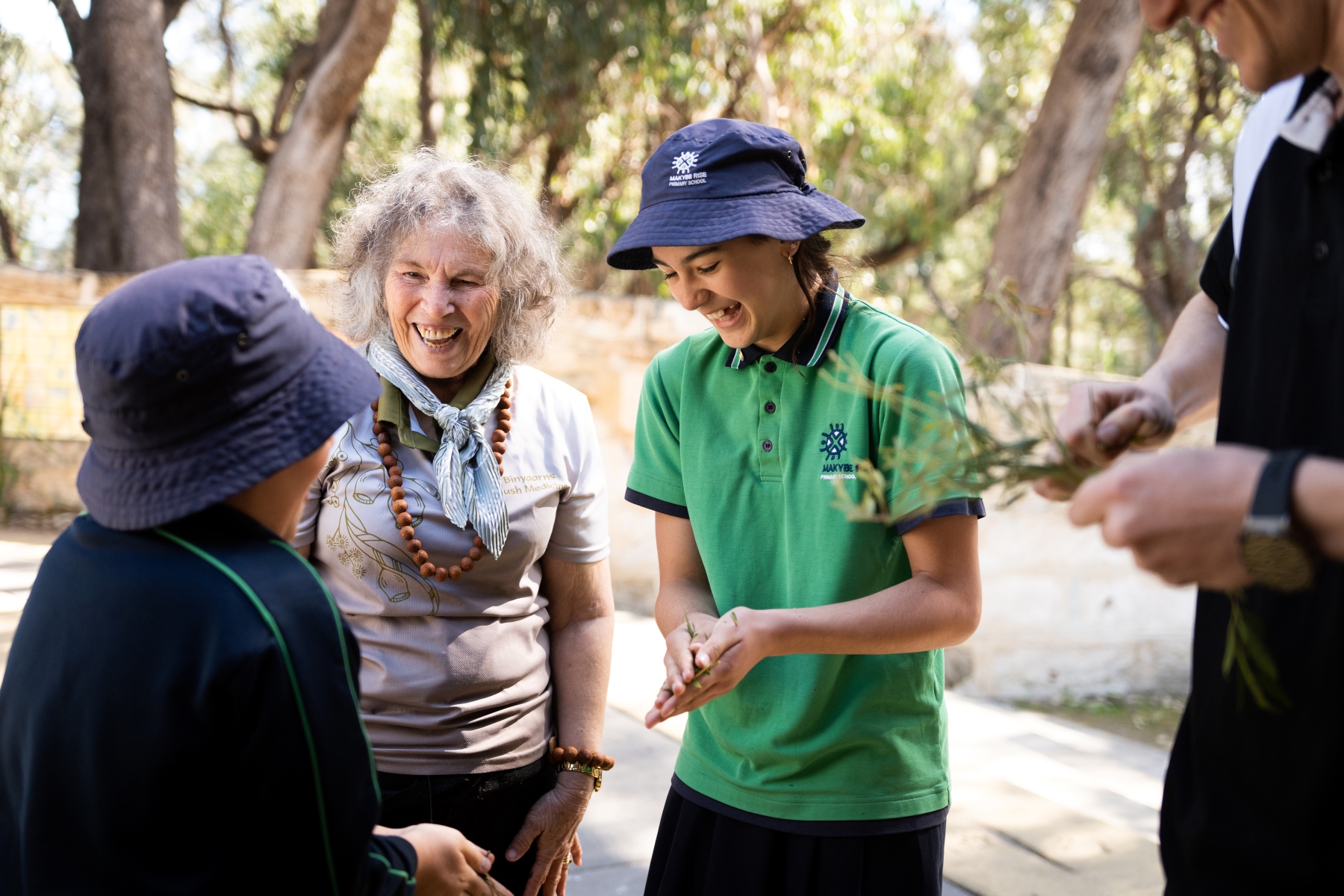 psa finalist ngaparrtji ngaparrtji staff working with two school students rubbing bush leaves 