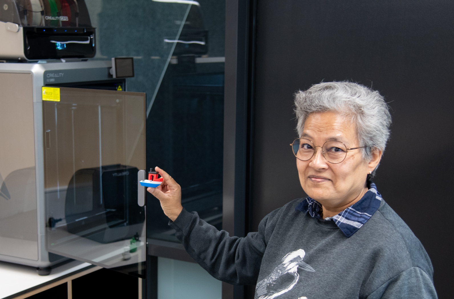 psa finalist roslyn london stading in front of a 3D printer holding a small boat print