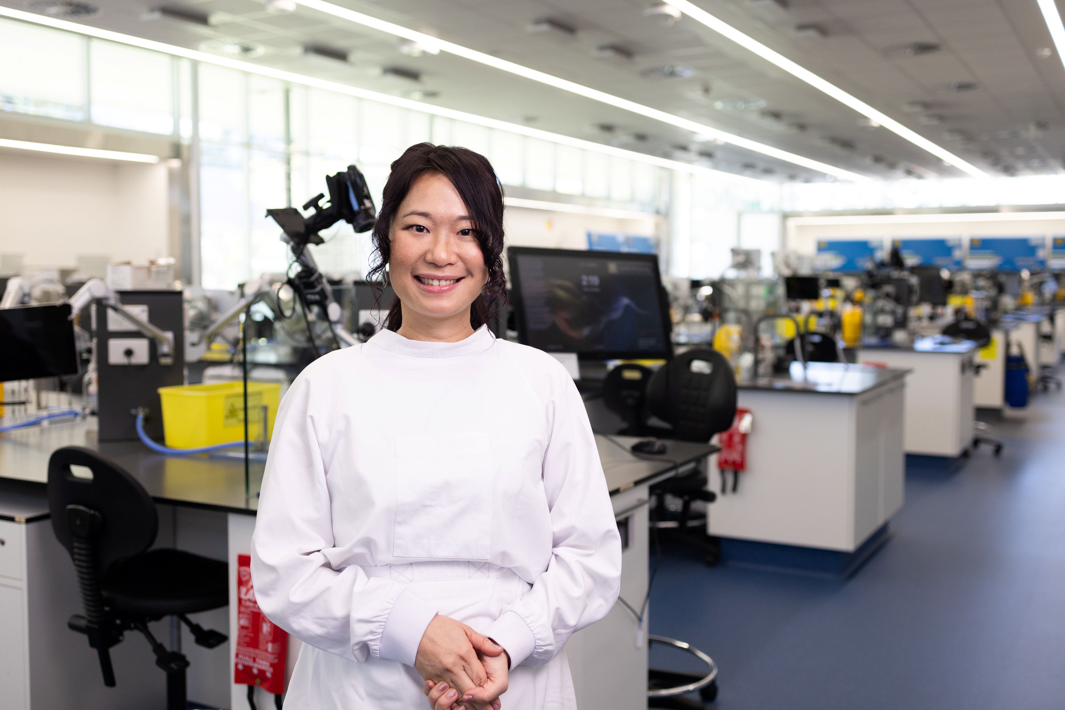 Rina in her lab wearing her lab coat