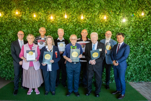 a group of 10 people, will dressed, holding there winners certificates to recognise their volunteering