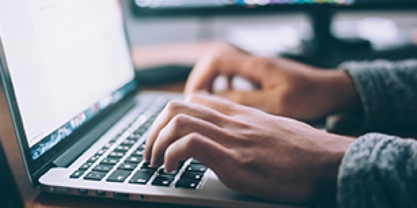 A man typing on a laptop