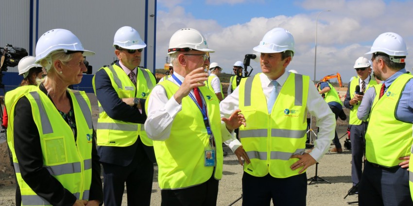 A group of men and women stand in a group wearing yellow high vis and white helmets. The people include the Premier of WA and key staff from the Department of Jobs, Tourism, Science and Innovation.