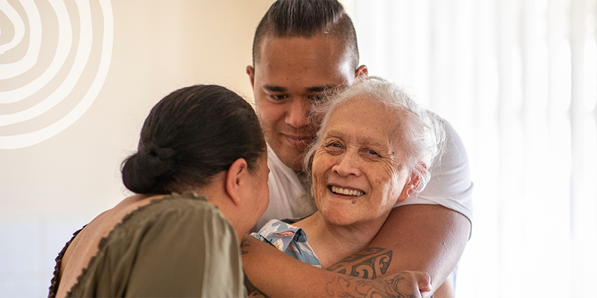 A grandmother smiling with her adult grandchildren.