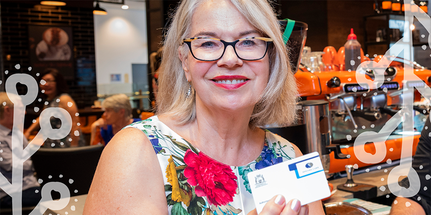 A senior person holding their WA seniors card.