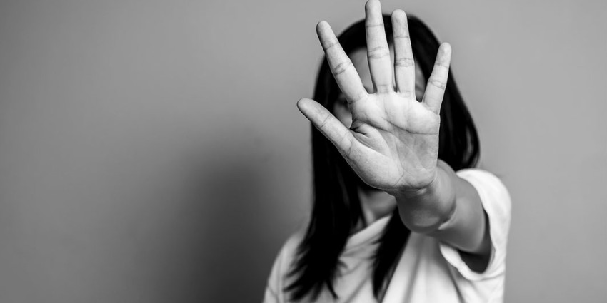 A woman with her hand held out in front of her face.