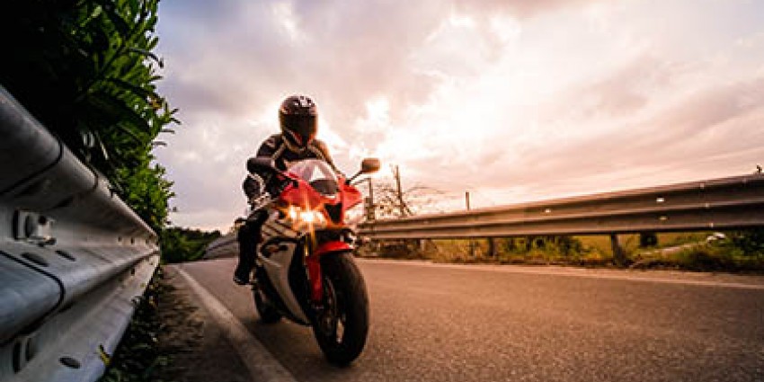 Person riding a motorcycle on a country road