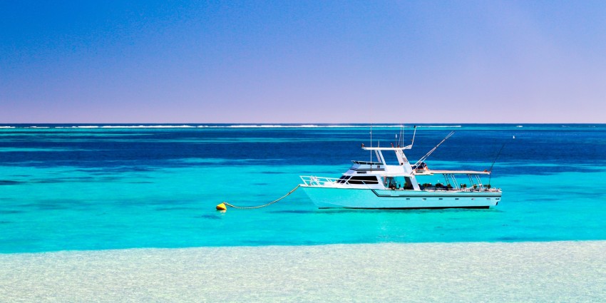 Image of A fishing and diving tour boat on a mooring behind Ningaloo Reef