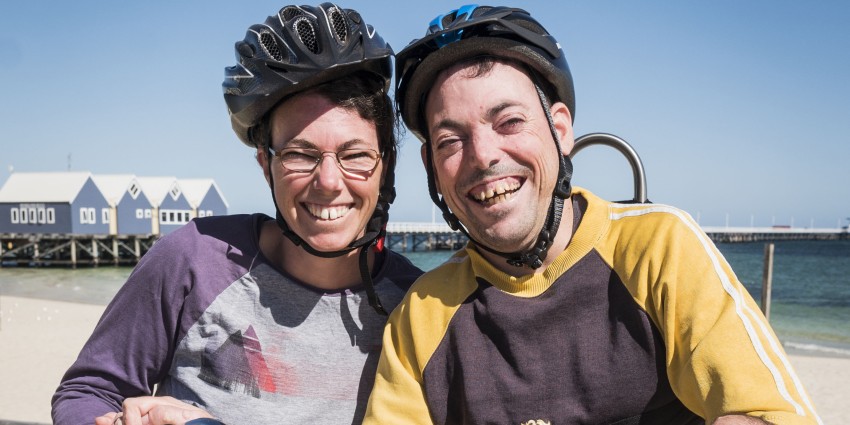 Two people on a beach, smiling.