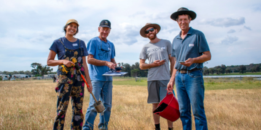 Four individuals standing in a field