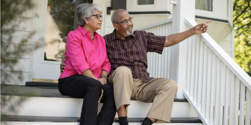 Husband and wife sitting at their home entrance and taking about their future