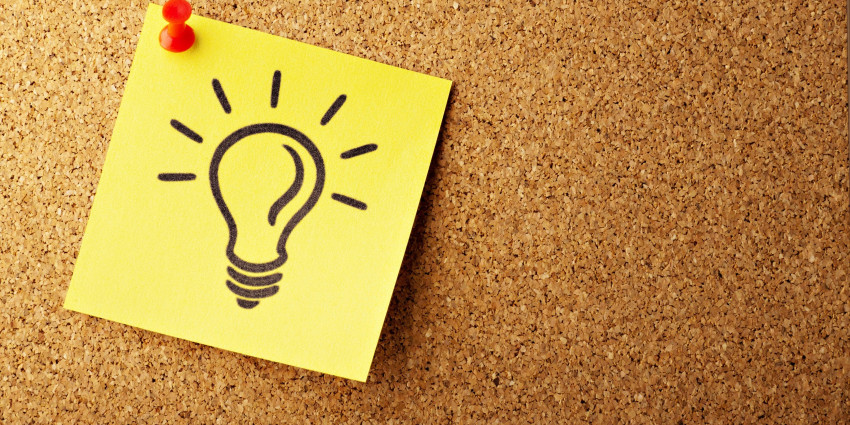 Lightbulb drawn onto a sticky note pinned up against board