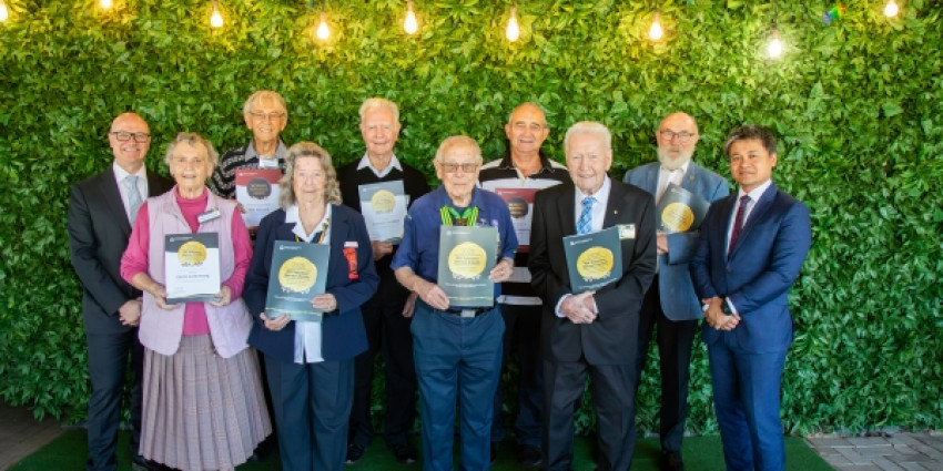 a group of 10 people, will dressed, holding there winners certificates to recognise their volunteering